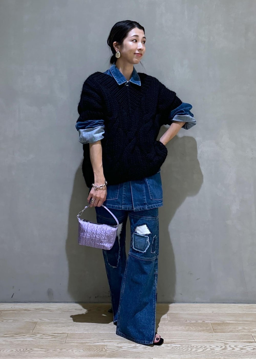パープル系のハンドバッグ、ブルー系のカバーオール、ブルー系のデニムパンツを着用したレディースの夏コーディネートの2枚目の写真