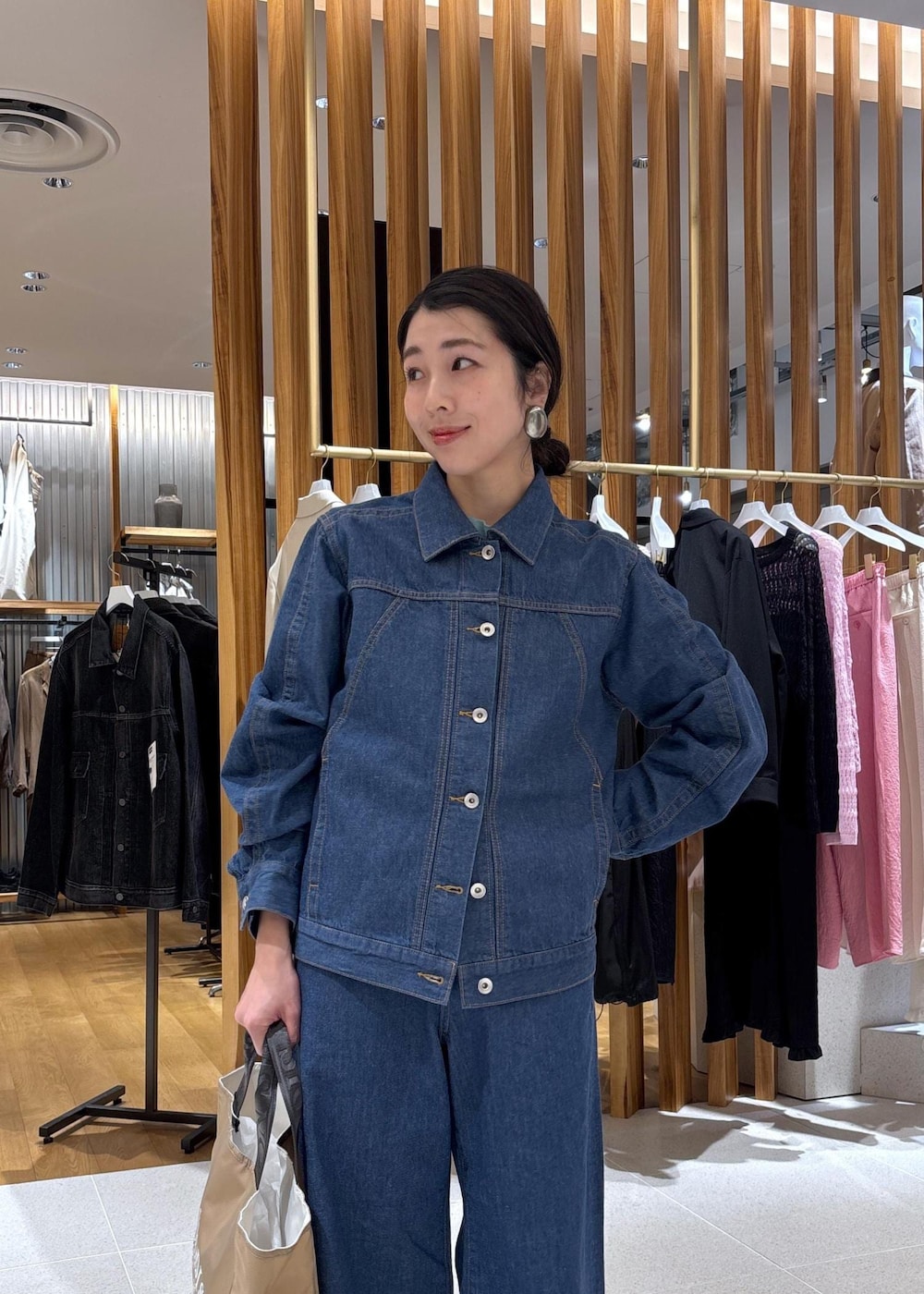 ベージュ系のハンドバッグ、ブルー系のTシャツ/カットソー、ブルー系のブルゾンを着用したレディースの冬コーディネートの8枚目の写真