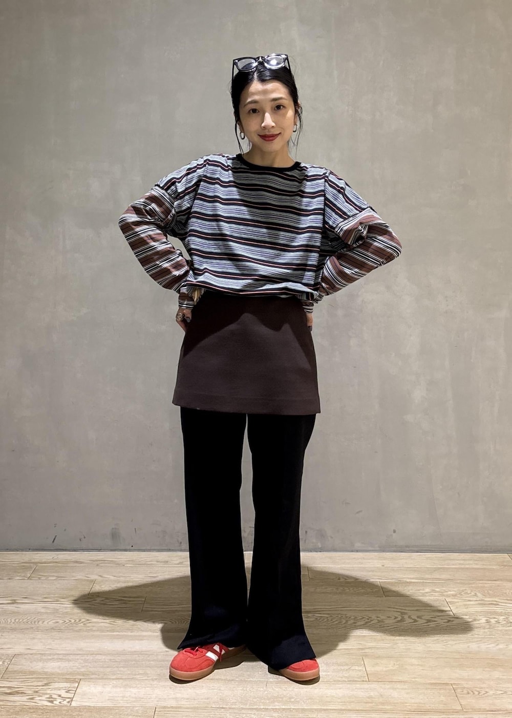 ブラック系のスラックス、ブラウン系のスカート、ブラック系のTシャツ/カットソーを着用したレディースの秋コーディネートの3枚目の写真