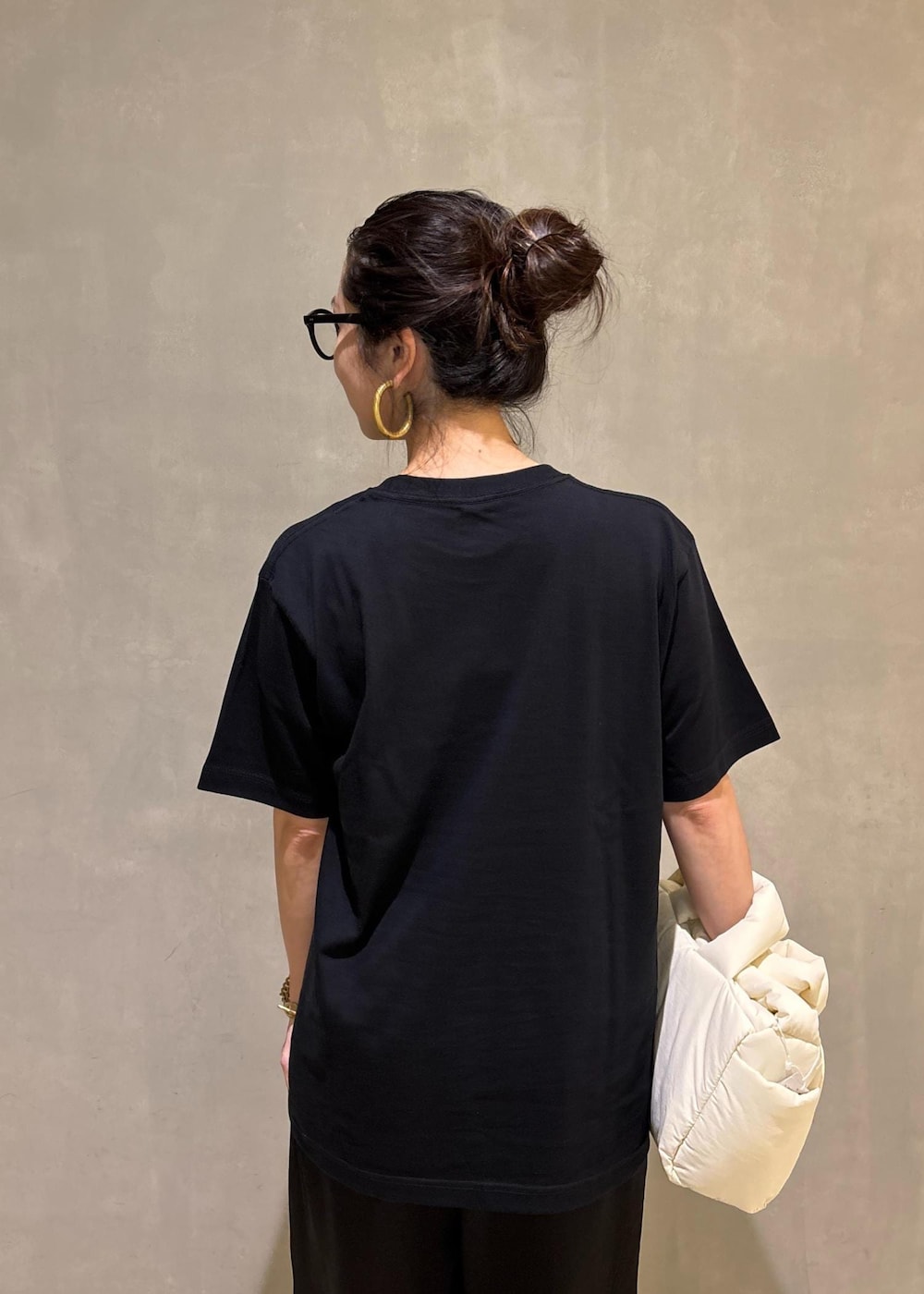 ブラック系のスラックス、イエロー系のTシャツ/カットソーを着用したレディースの夏コーディネートの9枚目の写真