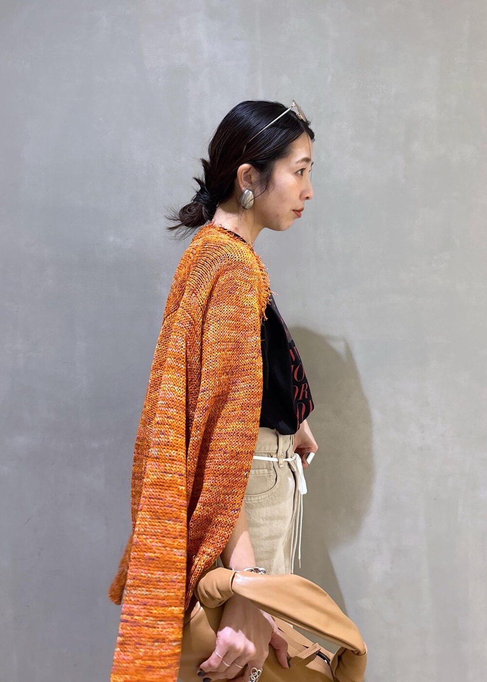 ベージュ系のハンドバッグ、ホワイト系のデニムパンツ、ホワイト系のTシャツ/カットソーを着用したレディースの春コーディネートの9枚目の写真