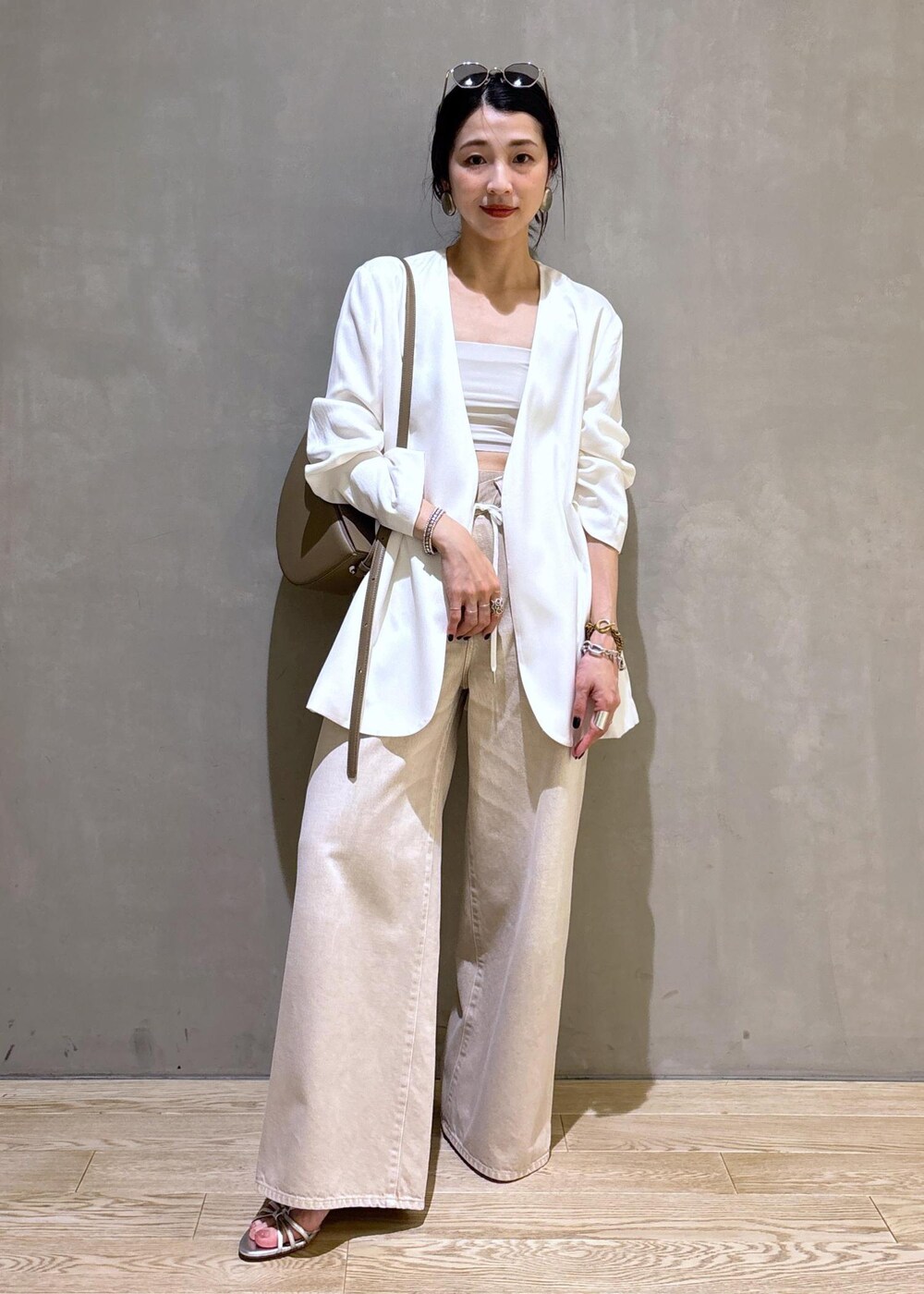 ホワイト系のノーカラージャケット、ホワイト系のデニムパンツ、グレー系のショルダーバッグを着用したレディースの春コーディネートの5枚目の写真