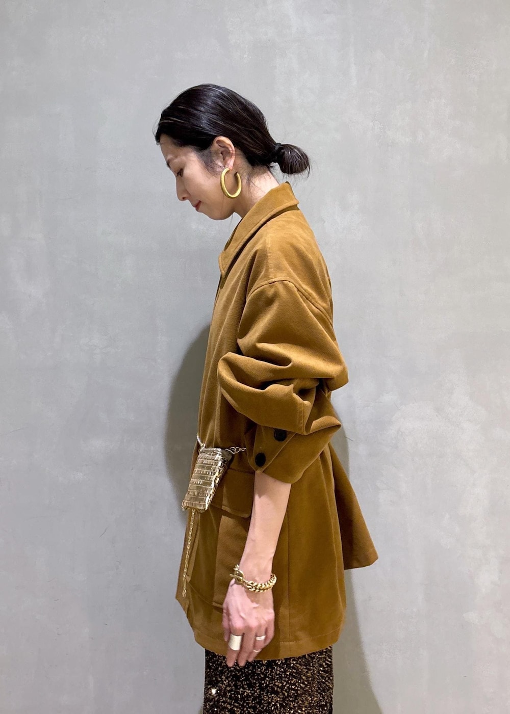 ブラック系のブーツ、ブラック系のスカート、イエロー系のブルゾンを着用したレディースの冬コーディネートの9枚目の写真