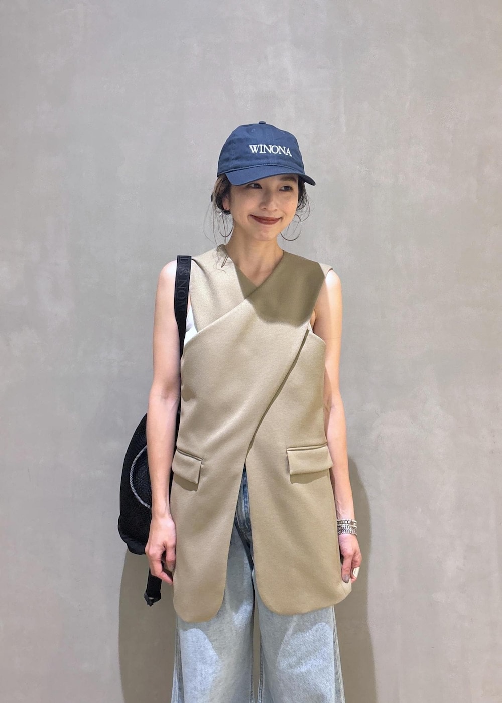 ベージュ系のベスト、ブラック系のスニーカー、ブラック系のショルダーバッグを着用したレディースの夏コーディネートの8枚目の写真