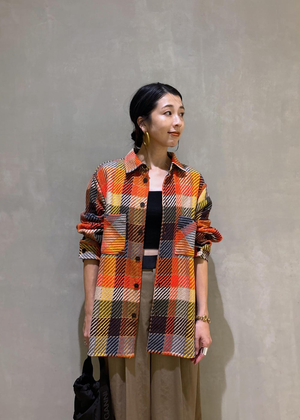 ブラック系のハンドバッグ、グリーン系のスラックスを着用したレディースの秋コーディネートの10枚目の写真