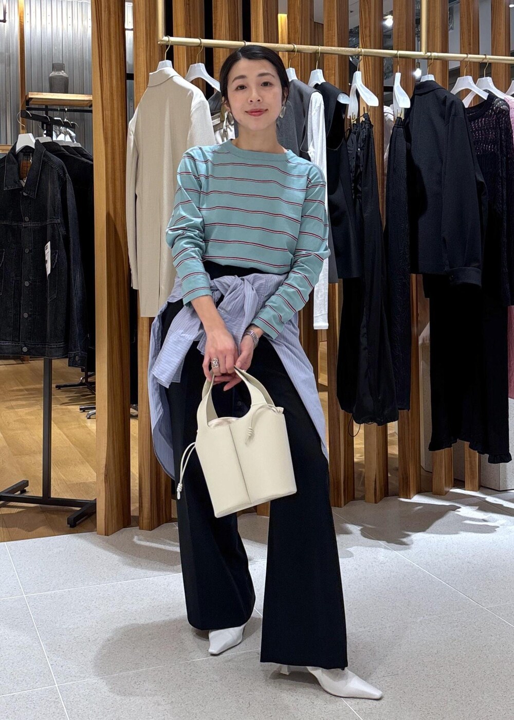 ホワイト系のパンプス、ブルー系のTシャツ/カットソー、ブルー系のシャツ/ブラウスを着用したレディースの冬コーディネートの2枚目の写真