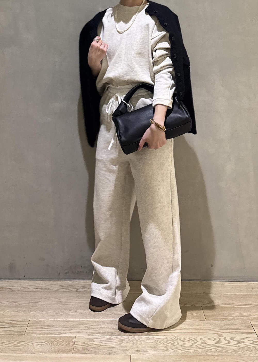 ブラック系のハンドバッグ、ホワイト系のその他パンツ、ホワイト系のスウェットを着用したレディースの冬コーディネートの8枚目の写真