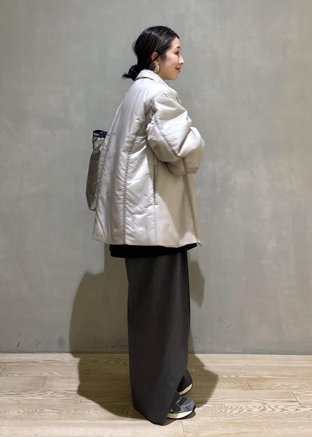 グレー系のスニーカー、ブラック系のシャツ/ブラウス、ベージュ系のブルゾンを着用したレディースの秋コーディネートの3枚目の写真