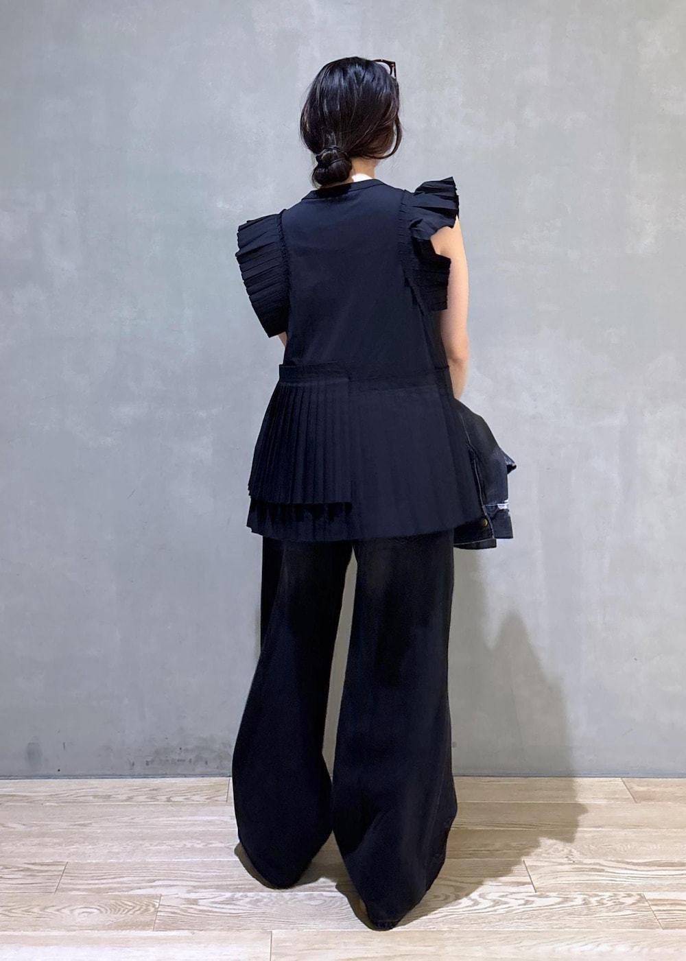 ブラック系のTシャツ/カットソー、ブラック系のデニムパンツ、ホワイト系のボストンバッグを着用したレディースの春コーディネートの4枚目の写真