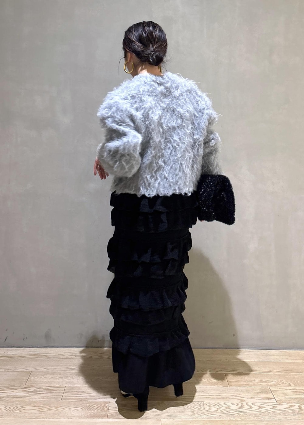 ブラック系のスカート、グレー系のカーディガン/ボレロ、ブラック系のトートバッグを着用したレディースの冬コーディネートの6枚目の写真