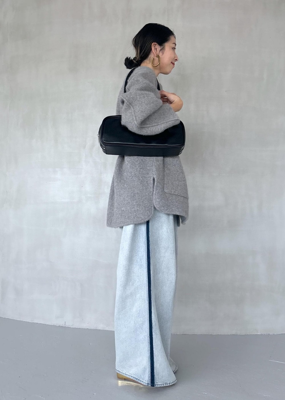 ゴールド系のパンプス、ブルー系のその他パンツ、ブラック系のボストンバッグを着用したレディースの秋コーディネートの4枚目の写真