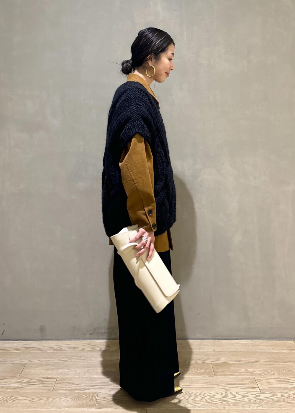 ブラック系のニット/セーター、ゴールド系のブーツ、イエロー系のブルゾンを着用したレディースの秋コーディネートの5枚目の写真