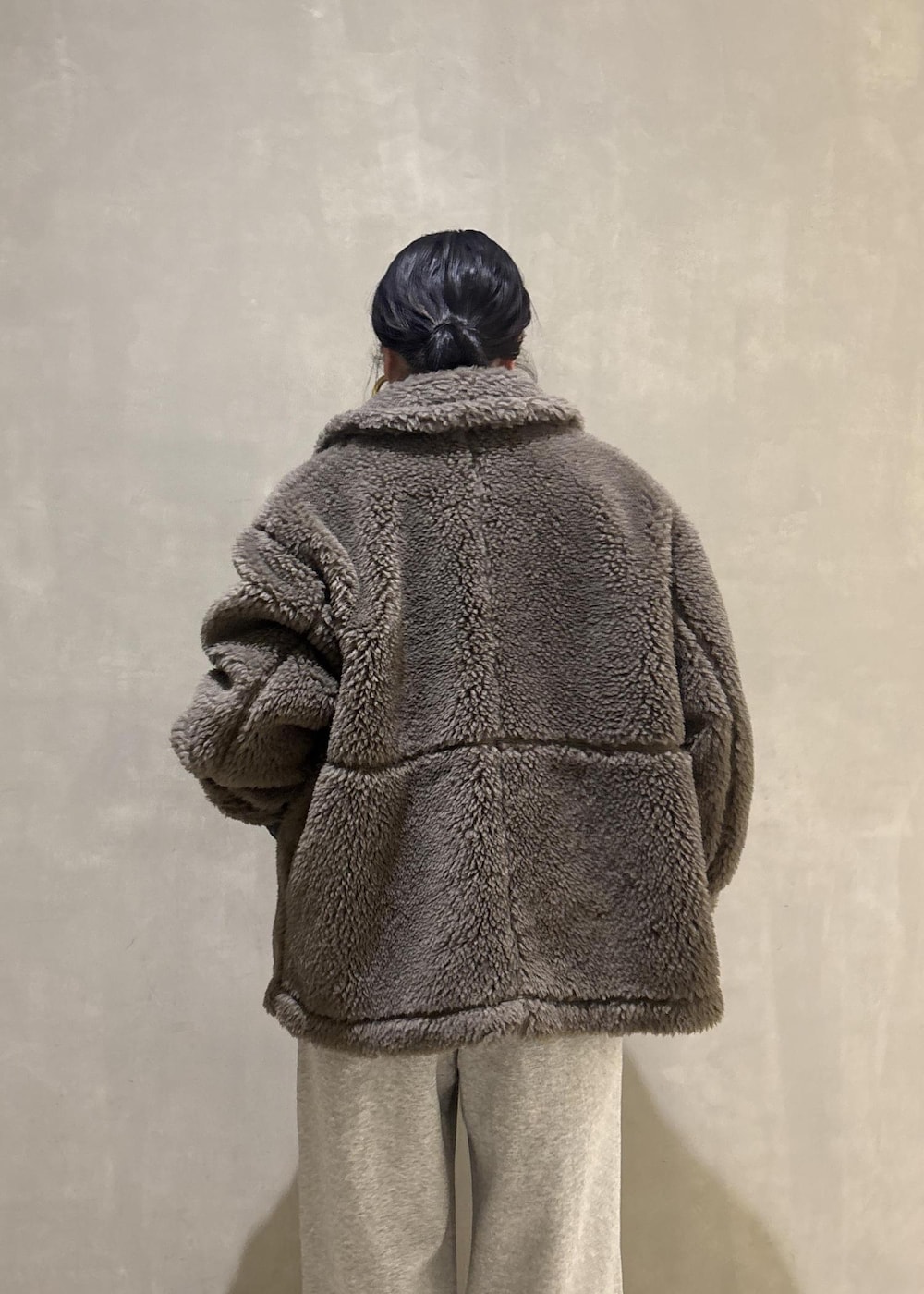 グリーン系のブルゾン、グレー系のその他パンツを着用したレディースの冬コーディネートの10枚目の写真