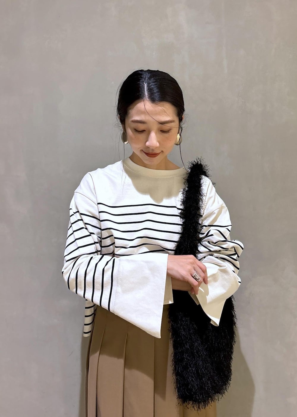 ベージュ系のスカート、ホワイト系のTシャツ/カットソー、ブラック系のハンドバッグを着用したレディースの夏コーディネートの7枚目の写真