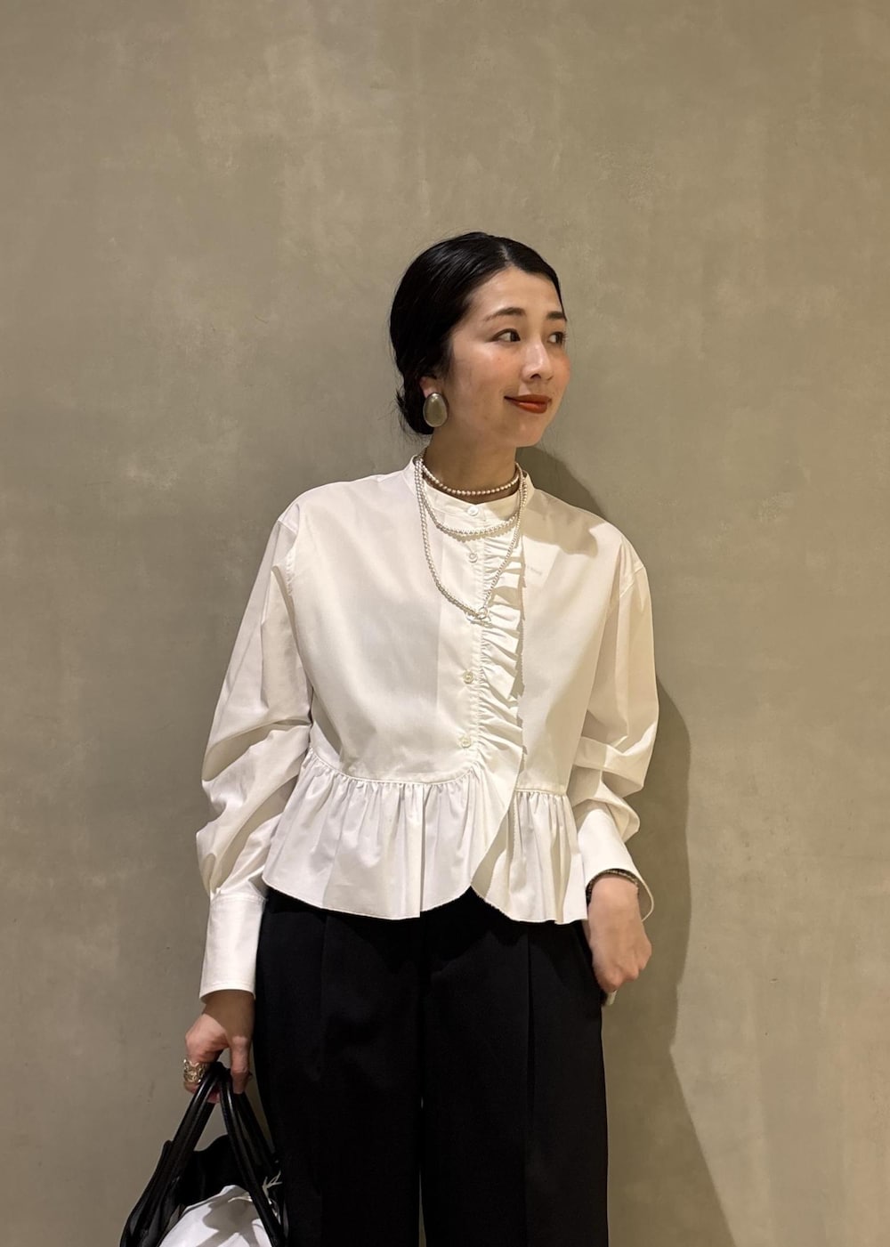 ホワイト系のシャツ/ブラウス、ブラック系のスラックス、ブラック系のトートバッグを着用したレディースの冬コーディネートの7枚目の写真