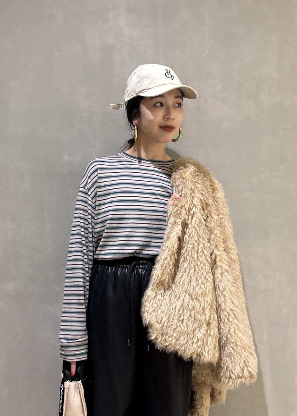 ベージュ系のトートバッグ、ベージュ系のその他アウター、ブラック系のその他パンツを着用したレディースの秋コーディネートの7枚目の写真