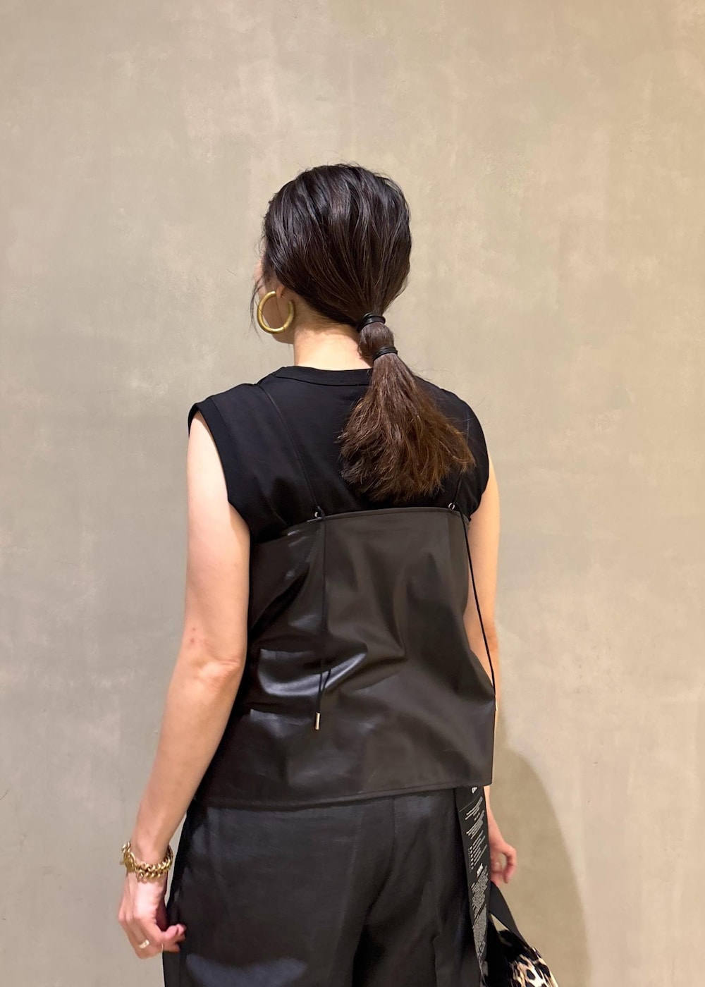 ブラック系のサンダル、ブラック系のデニムパンツ、ベージュ系のショルダーバッグを着用したレディースの夏コーディネートの9枚目の写真