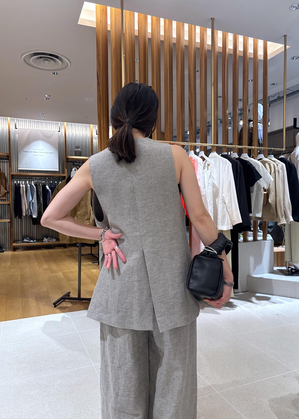 ブラック系のハンドバッグ、ベージュ系のその他パンツ、ベージュ系のベストを着用したレディースの春コーディネートの8枚目の写真