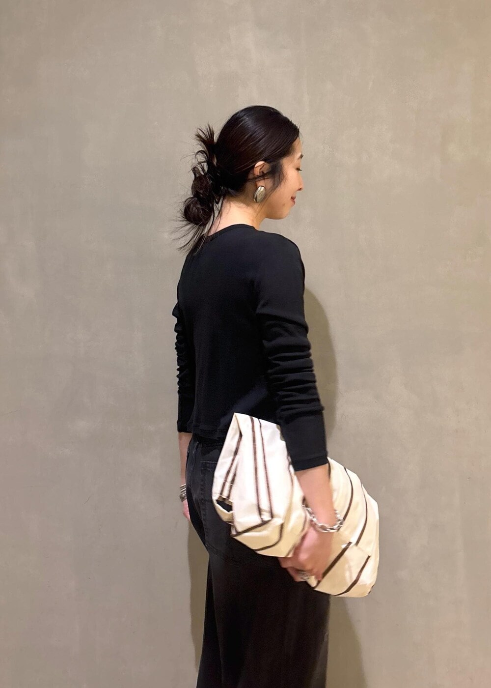 ブラック系のカーディガン/ボレロ、ホワイト系のショルダーバッグ、ブラック系のデニムパンツを着用したレディースの春コーディネートの9枚目の写真