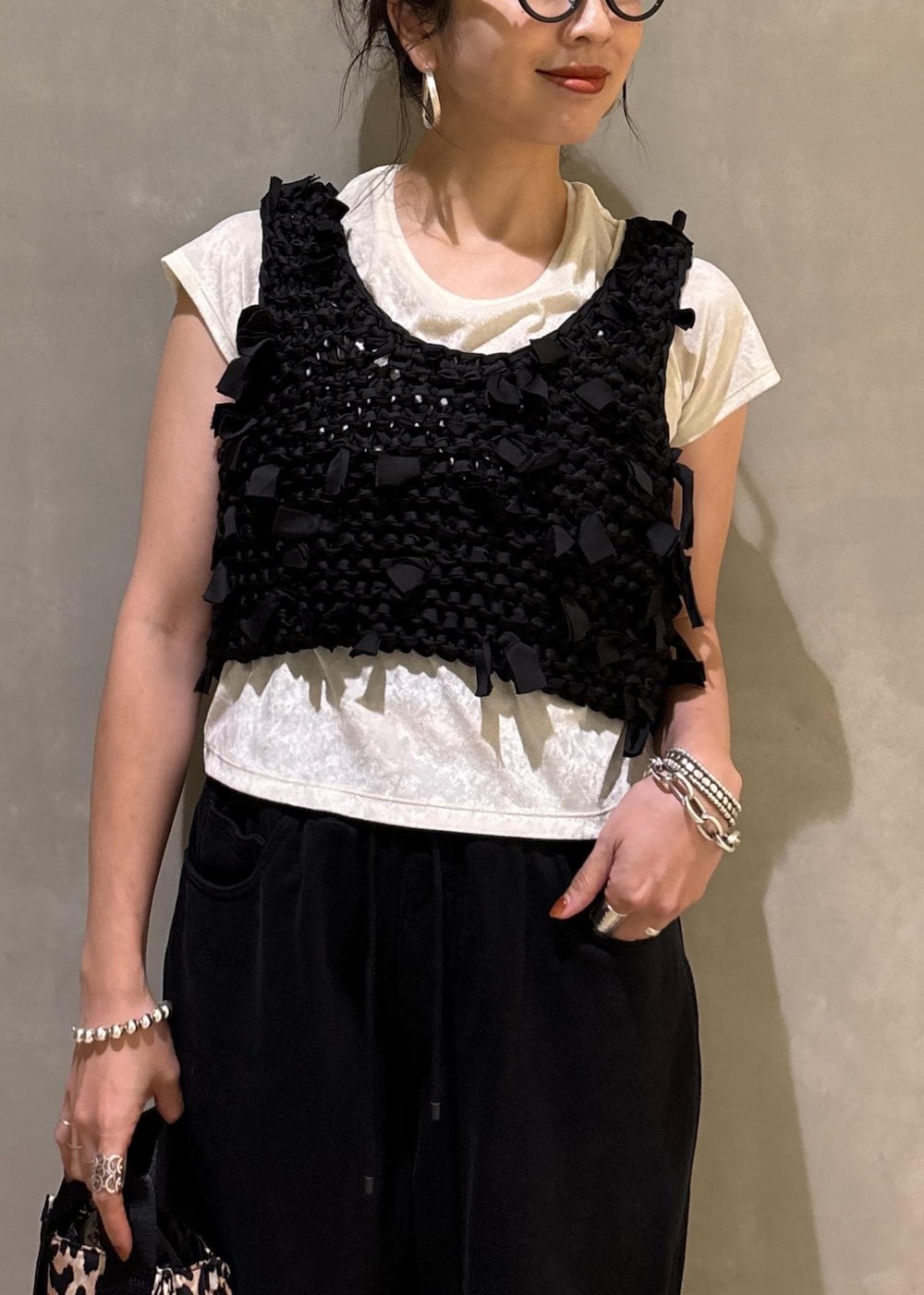 ホワイト系のTシャツ/カットソー、ベージュ系のショルダーバッグ、ブラック系のベストを着用したレディースの夏コーディネートの8枚目の写真