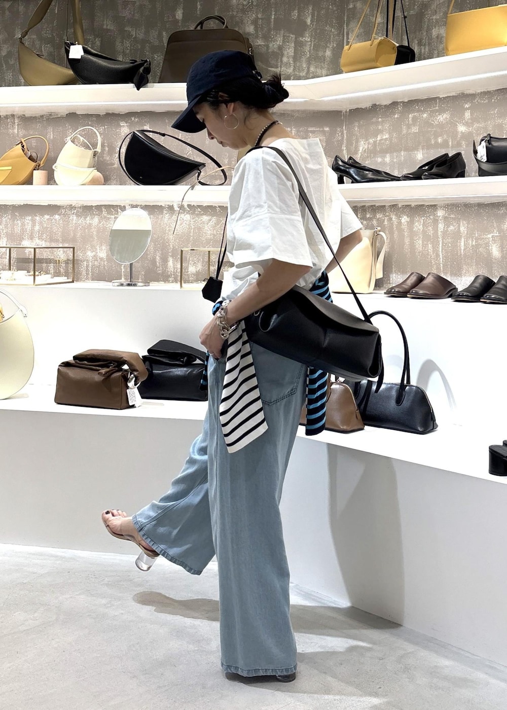 ブルー系のデニムパンツ、ブラック系のショルダーバッグ、ブルー系のTシャツ/カットソーを着用したレディースの春コーディネートの7枚目の写真