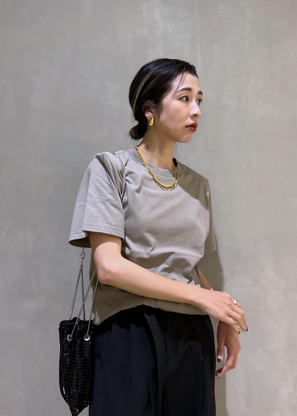 ブラック系のその他パンツ、ブラック系のハンドバッグ、グレー系のTシャツ/カットソーを着用したレディースの夏コーディネートの6枚目の写真