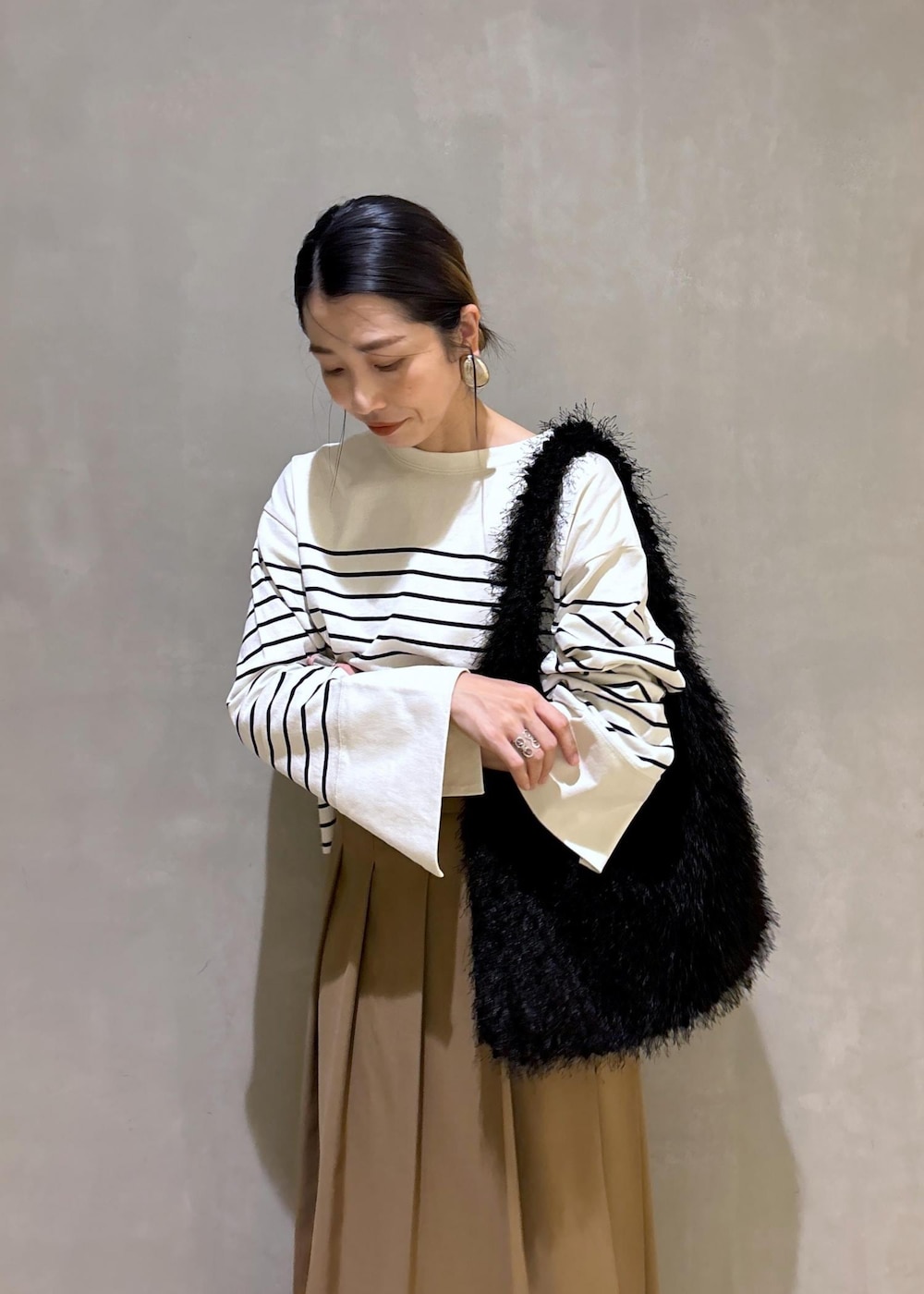 ベージュ系のスカート、ホワイト系のTシャツ/カットソー、ブラック系のハンドバッグを着用したレディースの夏コーディネートの9枚目の写真