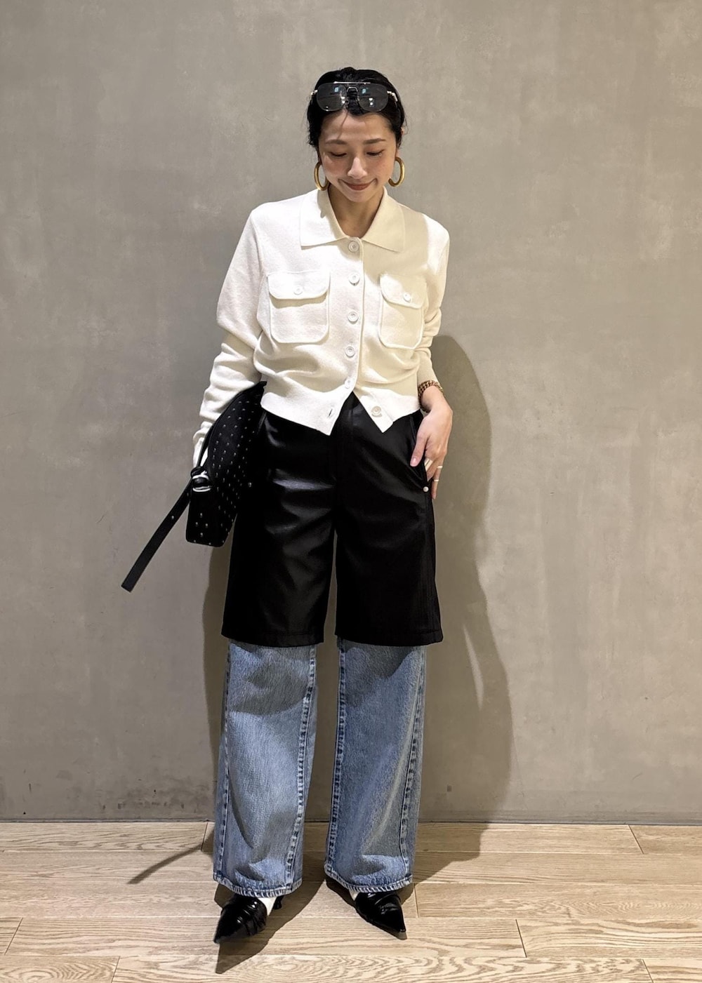 ブラック系のサンダル、ブルー系のデニムパンツ、ブラック系のダウンジャケット/コートを着用したレディースの冬コーディネートの2枚目の写真