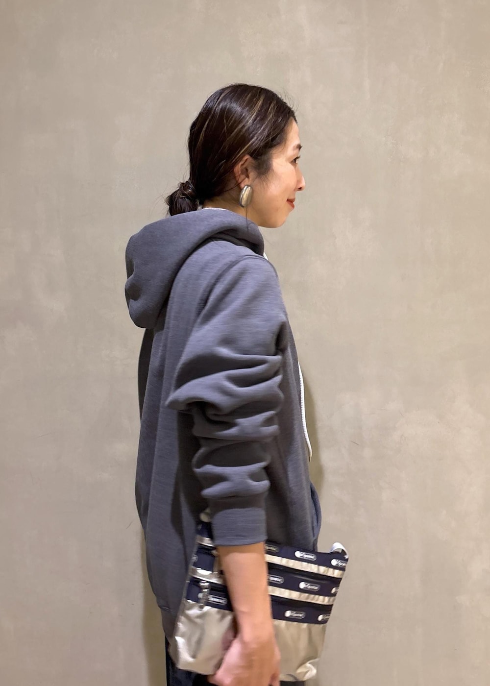 グレー系のスニーカー、ブラック系のスカート、グレー系のパーカーを着用したレディースの冬コーディネートの7枚目の写真