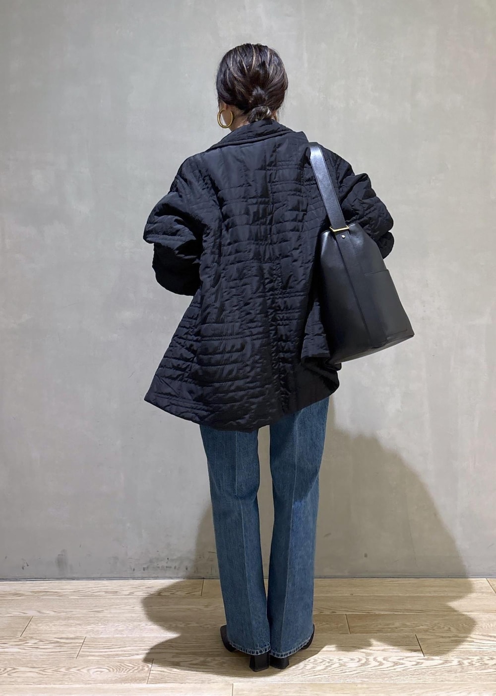 ブラック系のショルダーバッグ、ブルー系のシャツ/ブラウス、ブラック系のブルゾンを着用したレディースの冬コーディネートの3枚目の写真