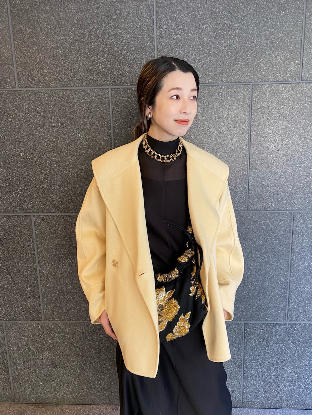 ブラック系のバッグ、ブラック系のワンピース、ブラック系のブーツを着用したレディースの春コーディネートの2枚目の写真