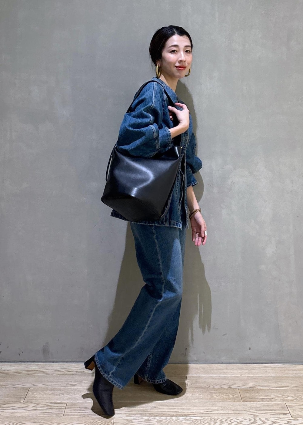 ブルー系のシャツ/ブラウス、ブルー系のデニムパンツ、ブラック系のショルダーバッグを着用したレディースの冬コーディネートの5枚目の写真