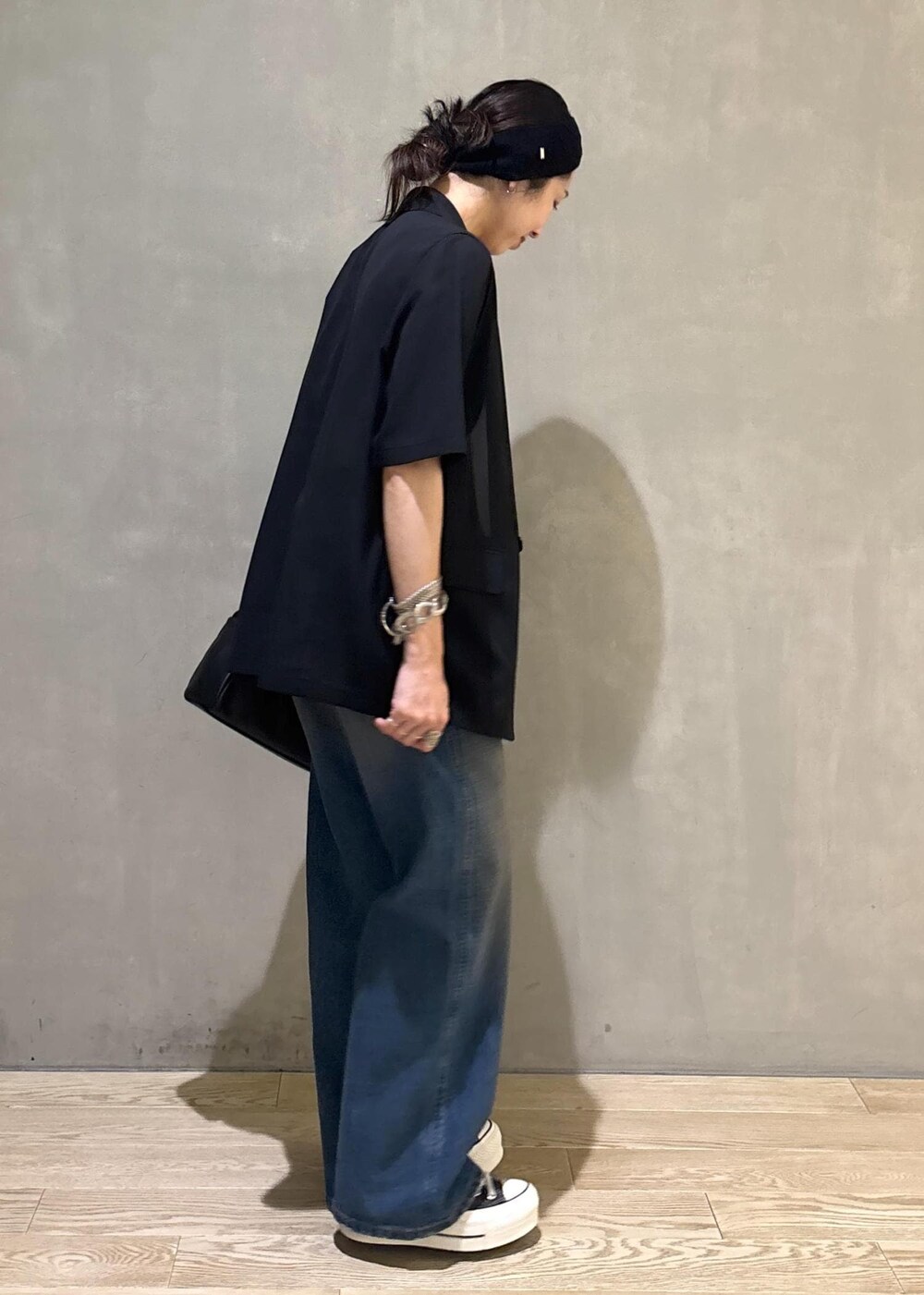 ブラック系のシャツ/ブラウス、ブルー系のデニムパンツ、シルバー系のネックレスを着用したレディースの夏コーディネートの4枚目の写真