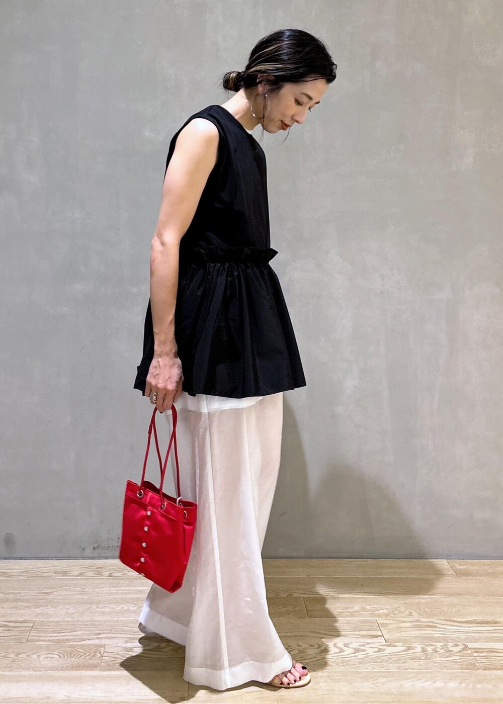 ホワイト系のタンクトップ、ホワイト系のその他パンツ、レッド系のハンドバッグを着用したレディースの夏コーディネートの4枚目の写真