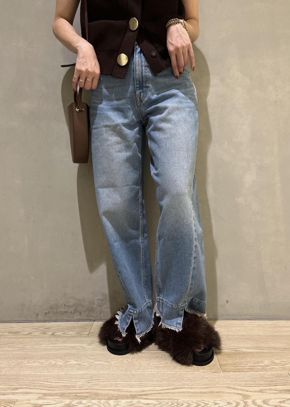 ブルー系のデニムパンツ、ブラウン系のサンダル、ブラウン系のベストを着用したレディースの夏コーディネートの6枚目の写真