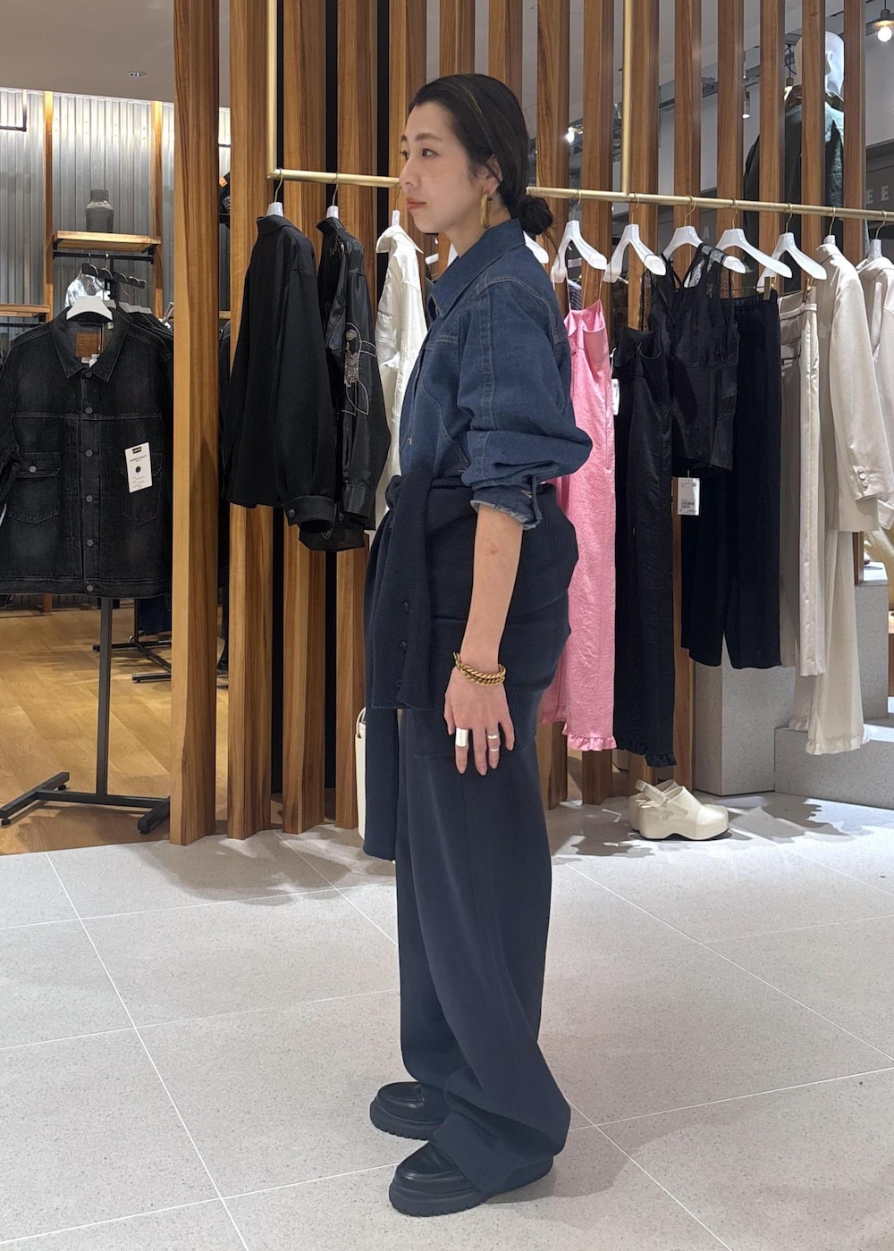 ブラック系のローファー、ホワイト系のハンドバッグ、ブルー系のブルゾンを着用したレディースの春コーディネートの5枚目の写真