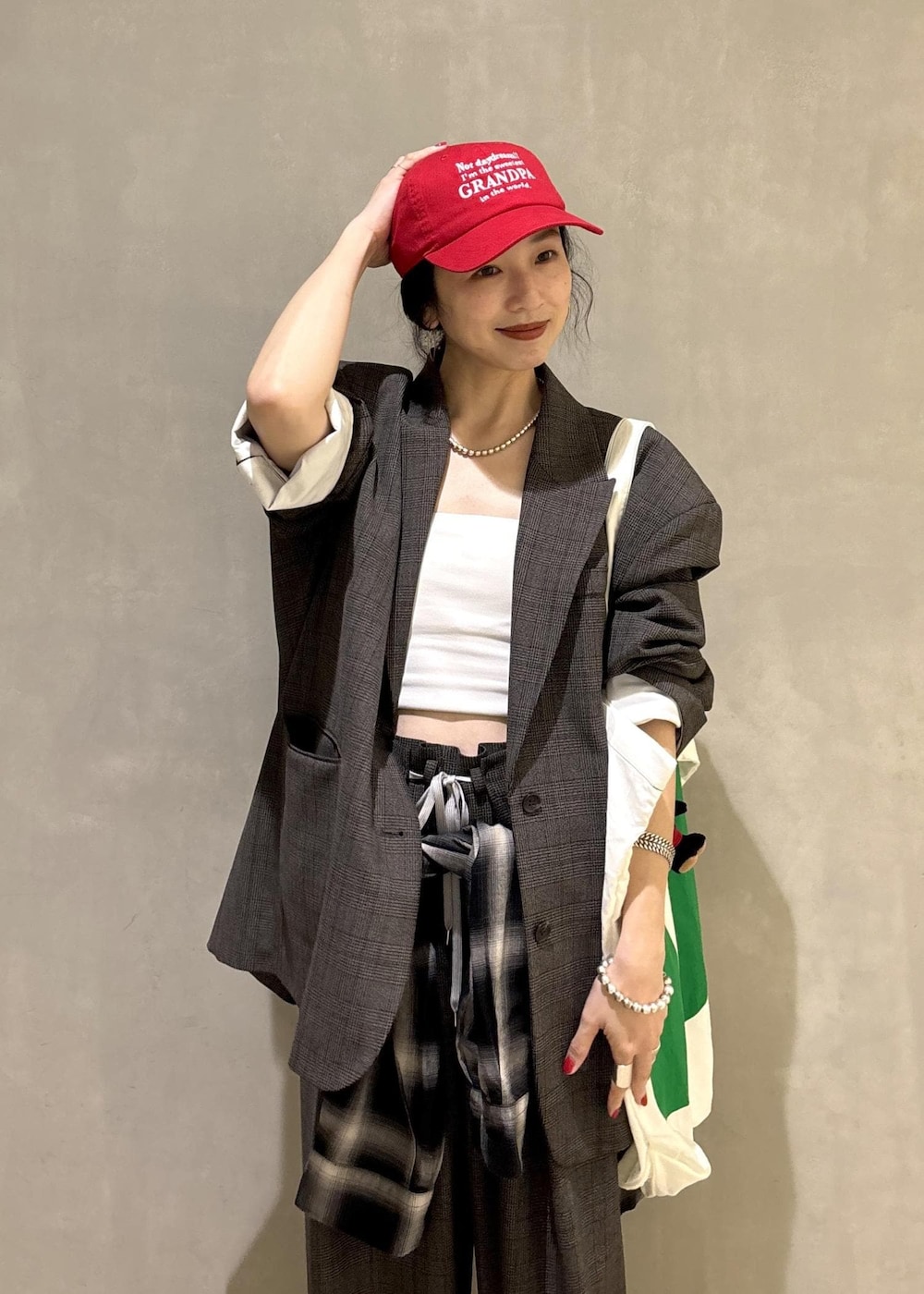 ブラック系のシャツ/ブラウス、グリーン系のトートバッグ、ブラック系のキャップを着用したレディースの秋コーディネートの8枚目の写真