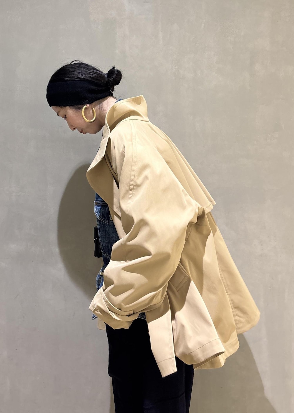 ベージュ系のトレンチコート、ブルー系のデニムジャケット、ブルー系のその他パンツを着用したレディースの春コーディネートの9枚目の写真