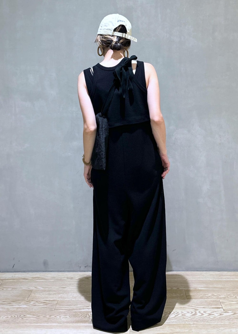 ブラック系のスニーカー、ブラック系のつなぎ/オールインワン、ベージュ系のキャップを着用したレディースの夏コーディネートの4枚目の写真