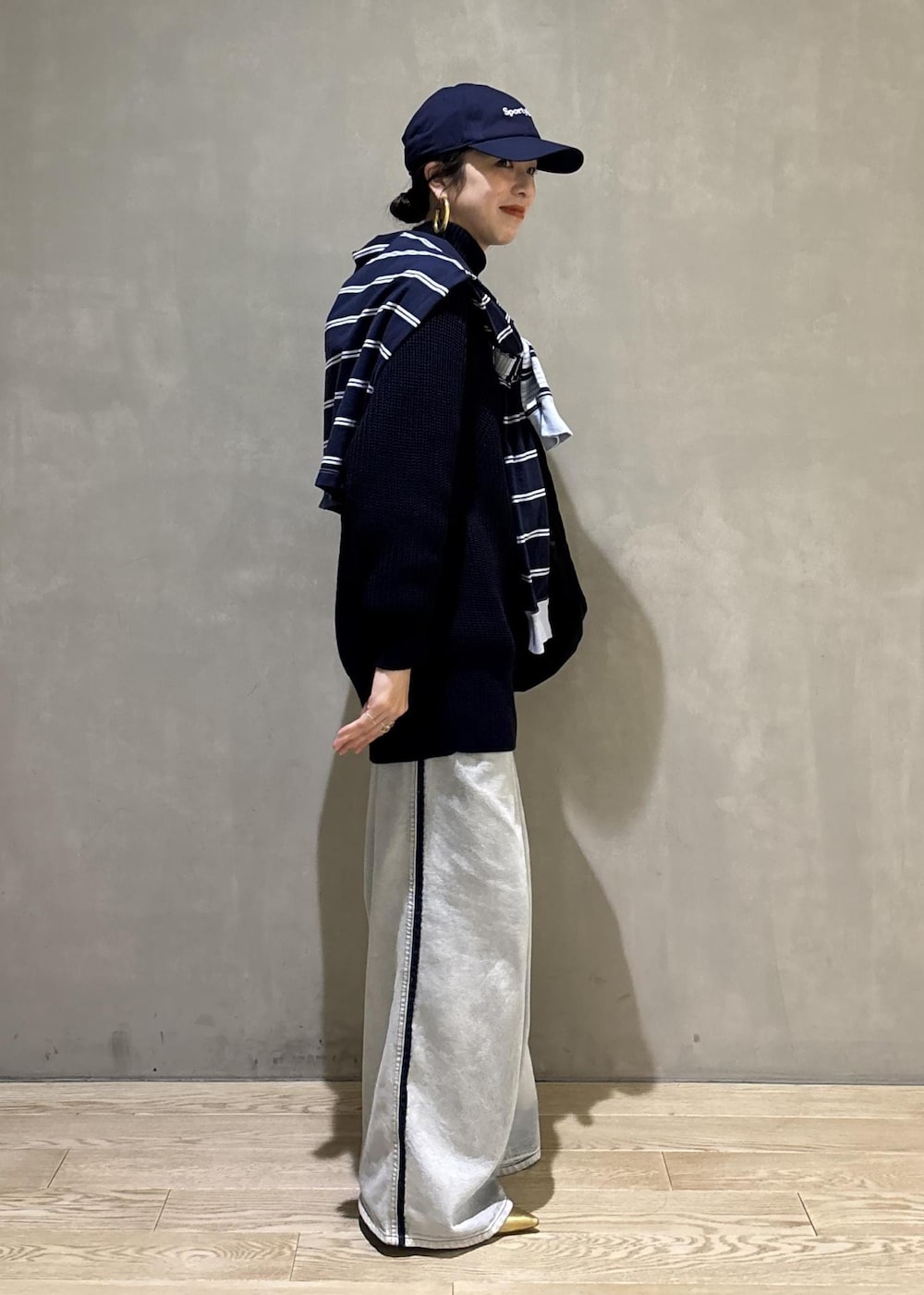 ブルー系のデニムパンツ、ブラック系のショルダーバッグを着用したレディースの秋コーディネートの5枚目の写真