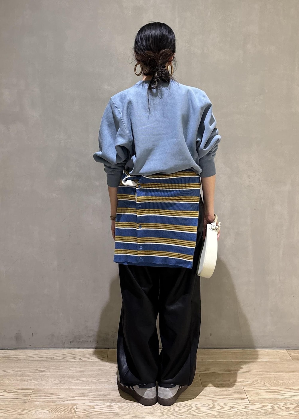 ホワイト系のハンドバッグ、ブルー系のスウェット、ブルー系のポロシャツを着用したレディースの秋コーディネートの4枚目の写真