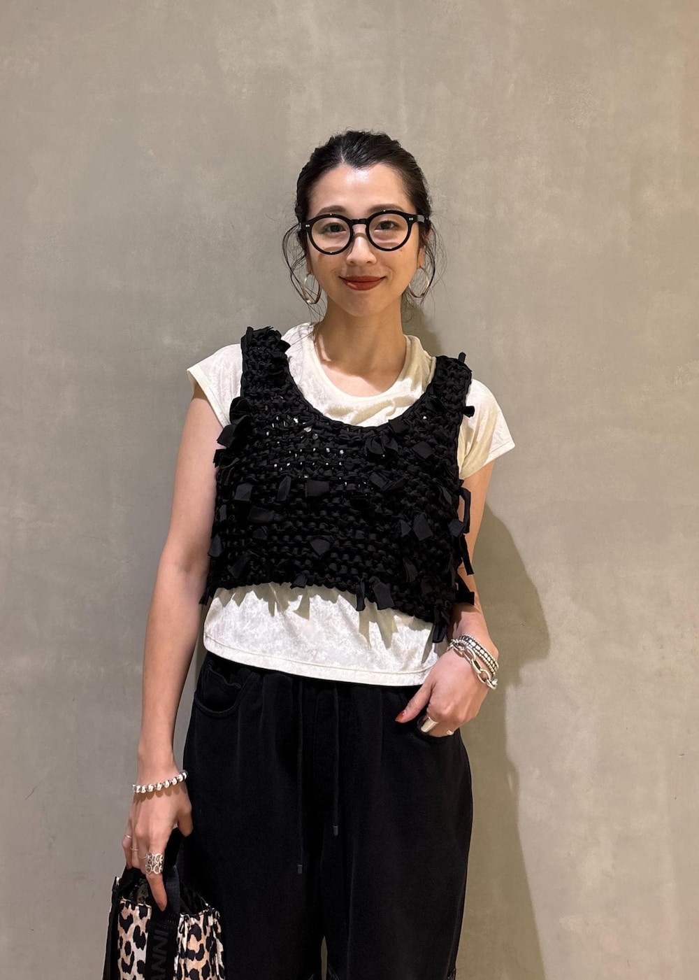 ホワイト系のTシャツ/カットソー、ベージュ系のショルダーバッグ、ブラック系のベストを着用したレディースの夏コーディネートの7枚目の写真