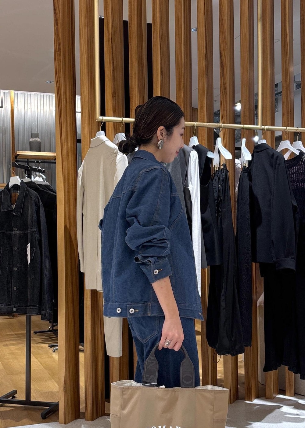 ベージュ系のハンドバッグ、ブルー系のTシャツ/カットソー、ブルー系のブルゾンを着用したレディースの冬コーディネートの10枚目の写真