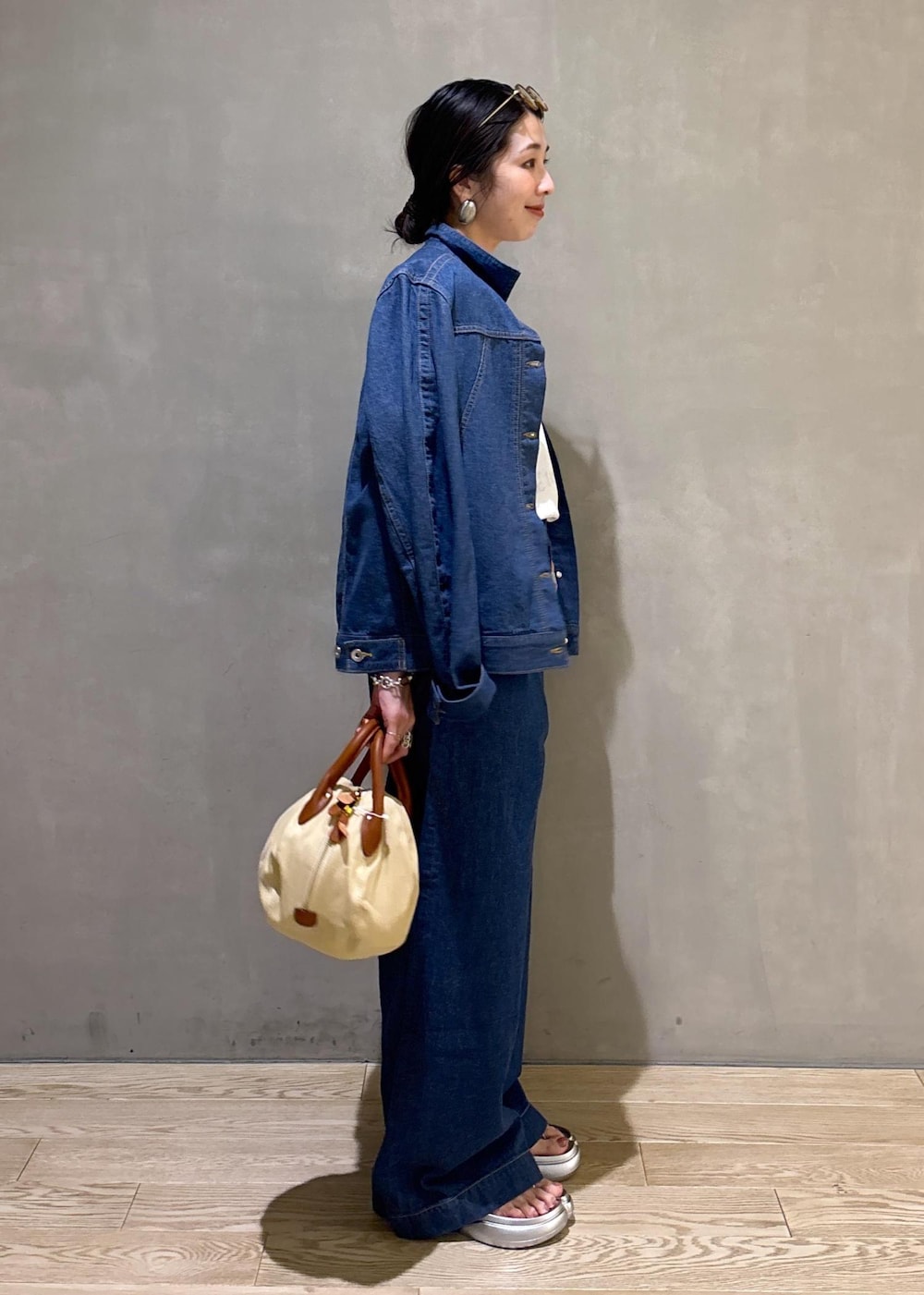 ブルー系のブルゾン、ブルー系のデニムパンツ、ホワイト系のTシャツ/カットソーを着用したレディースの春コーディネートの3枚目の写真