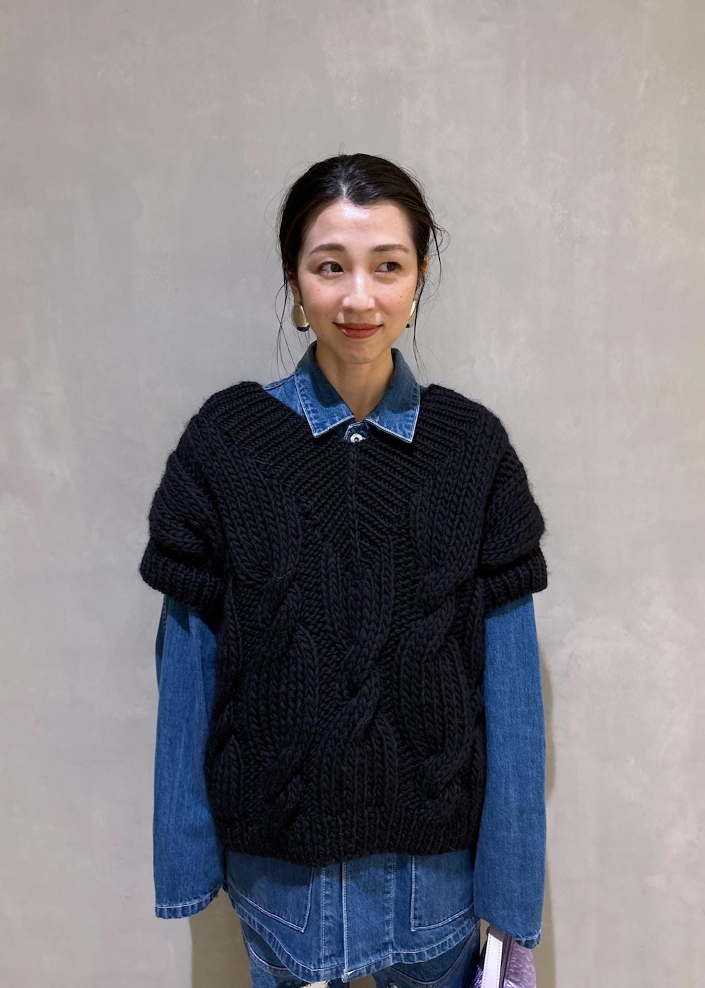 パープル系のハンドバッグ、ブルー系のカバーオール、ブルー系のデニムパンツを着用したレディースの夏コーディネートの6枚目の写真