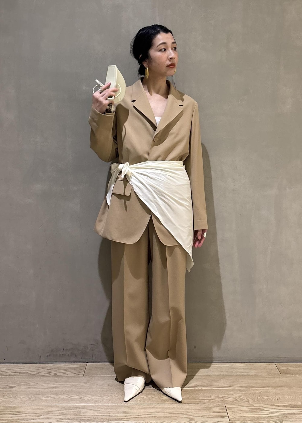 ベージュ系のテーラードジャケット、ホワイト系のシャツ/ブラウス、ベージュ系のスラックスを着用したレディースの冬コーディネートの4枚目の写真