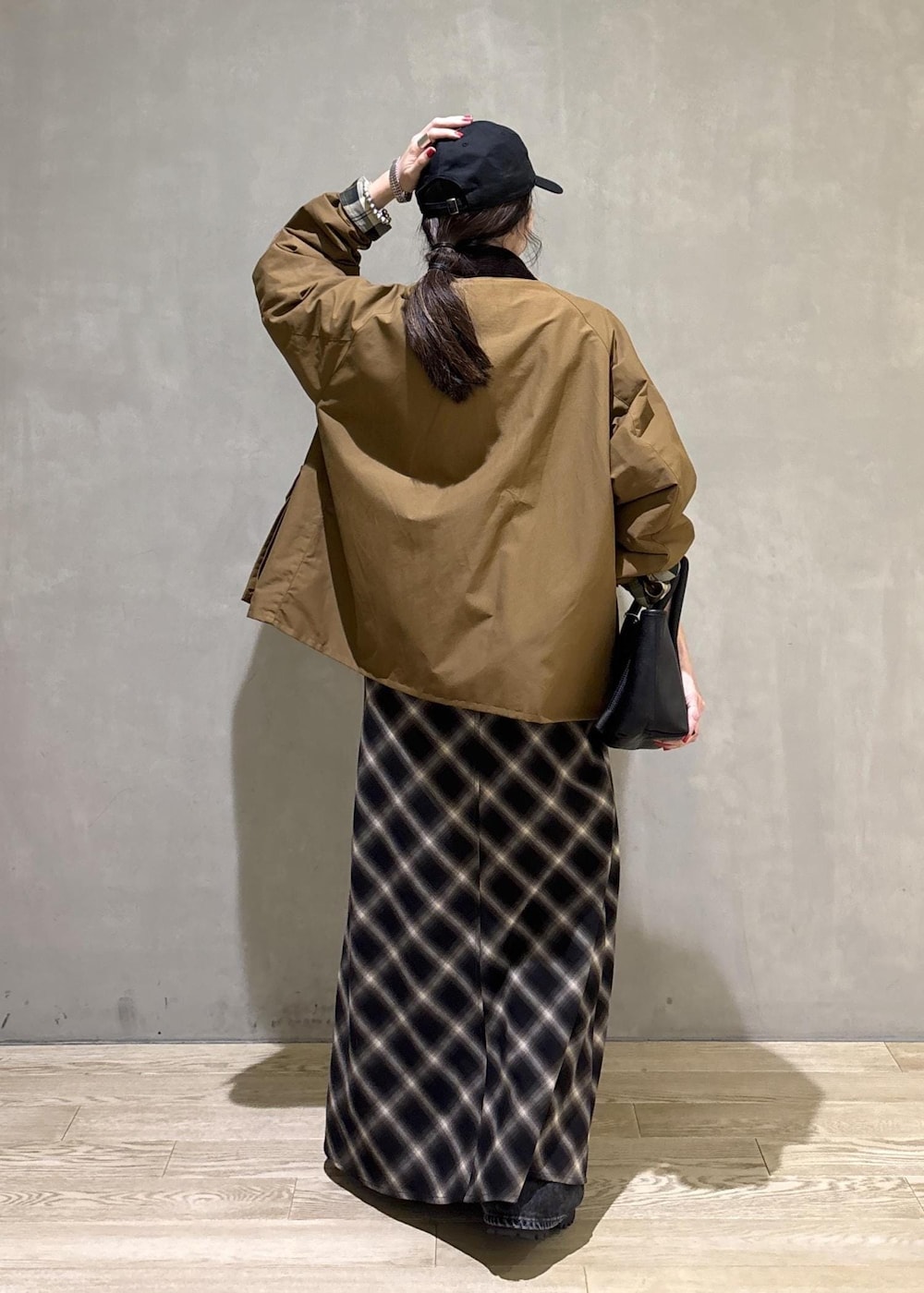 イエロー系のブルゾン、ブラック系のキャップを着用したレディースの秋コーディネートの4枚目の写真