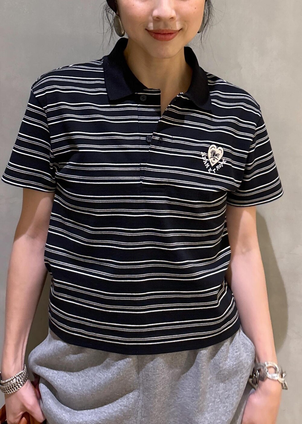 グレー系のスウェットパンツ、ブラック系のポロシャツを着用したレディースの夏コーディネートの8枚目の写真