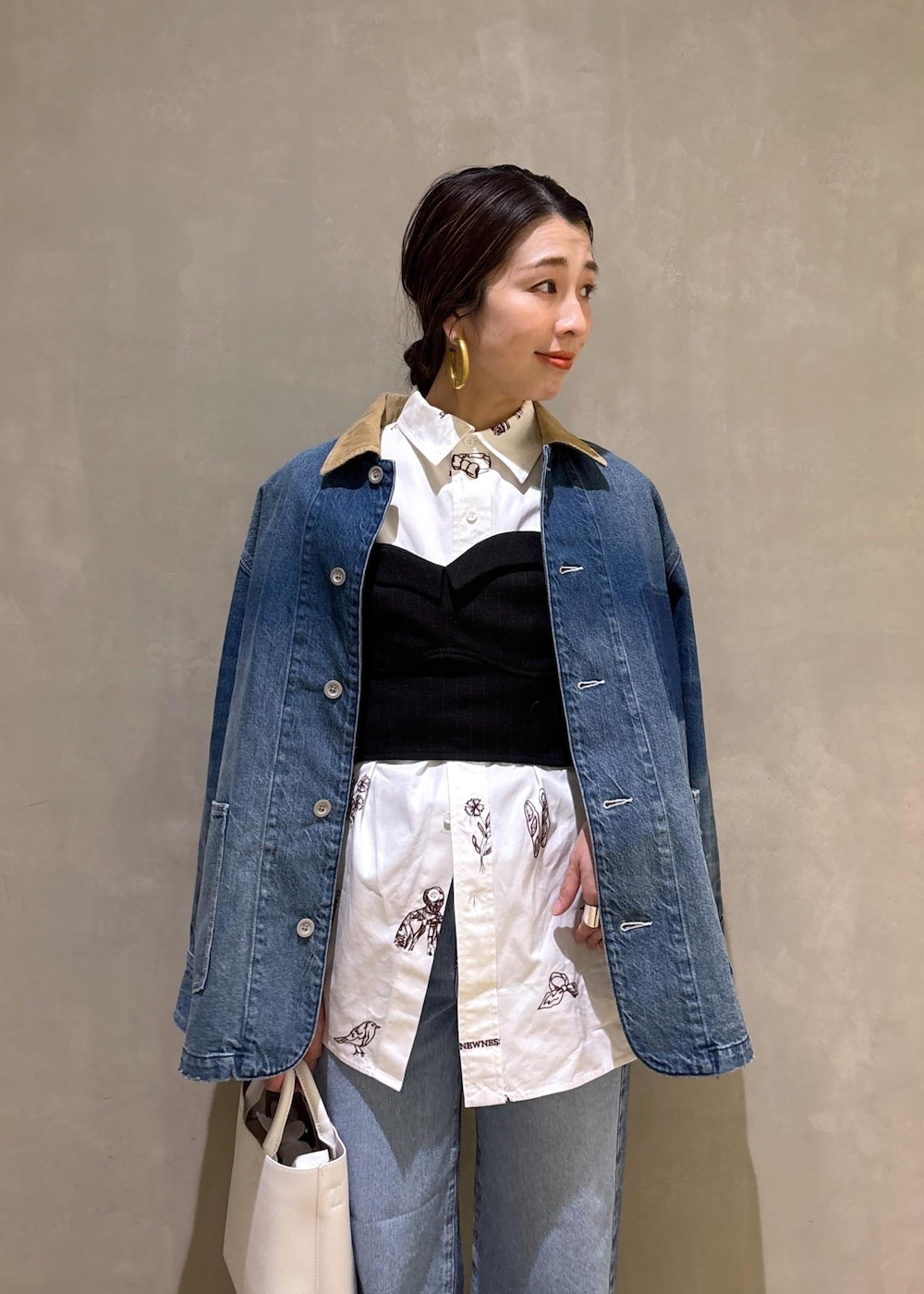 ホワイト系のハンドバッグ、ブルー系のデニムパンツ、ブルー系のデニムジャケットを着用したレディースの冬コーディネートの8枚目の写真