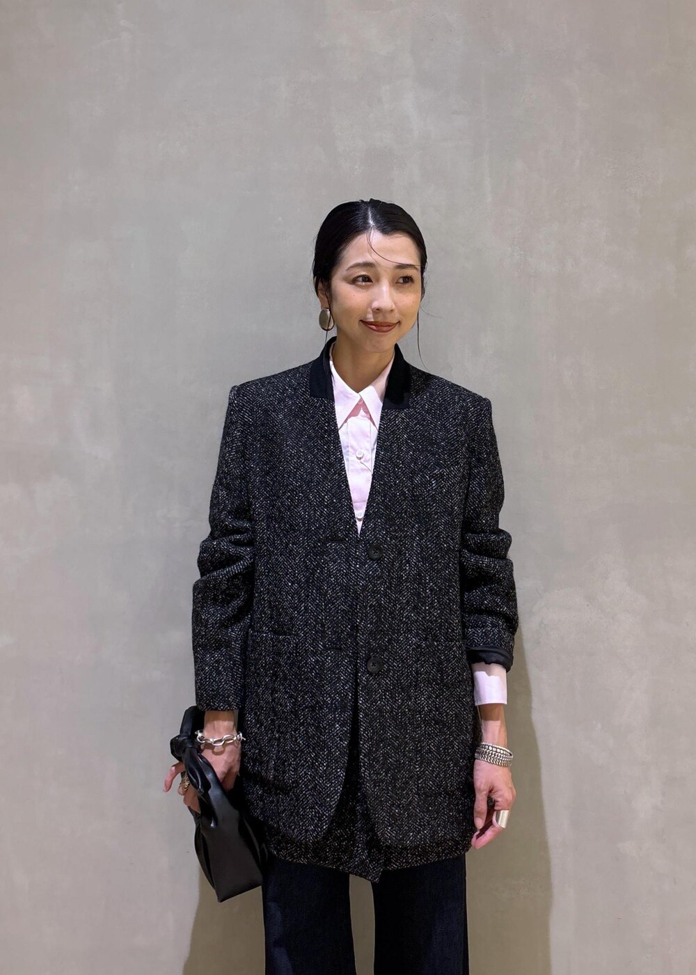 ブラック系のショルダーバッグ、ホワイト系のパンプス、ブルー系のデニムパンツを着用したレディースの夏コーディネートの8枚目の写真